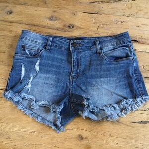 29” STS Blue jean shorts feature a distressed design with a dark blue wash